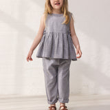 Children wearing a net top with peplum and matching pants.