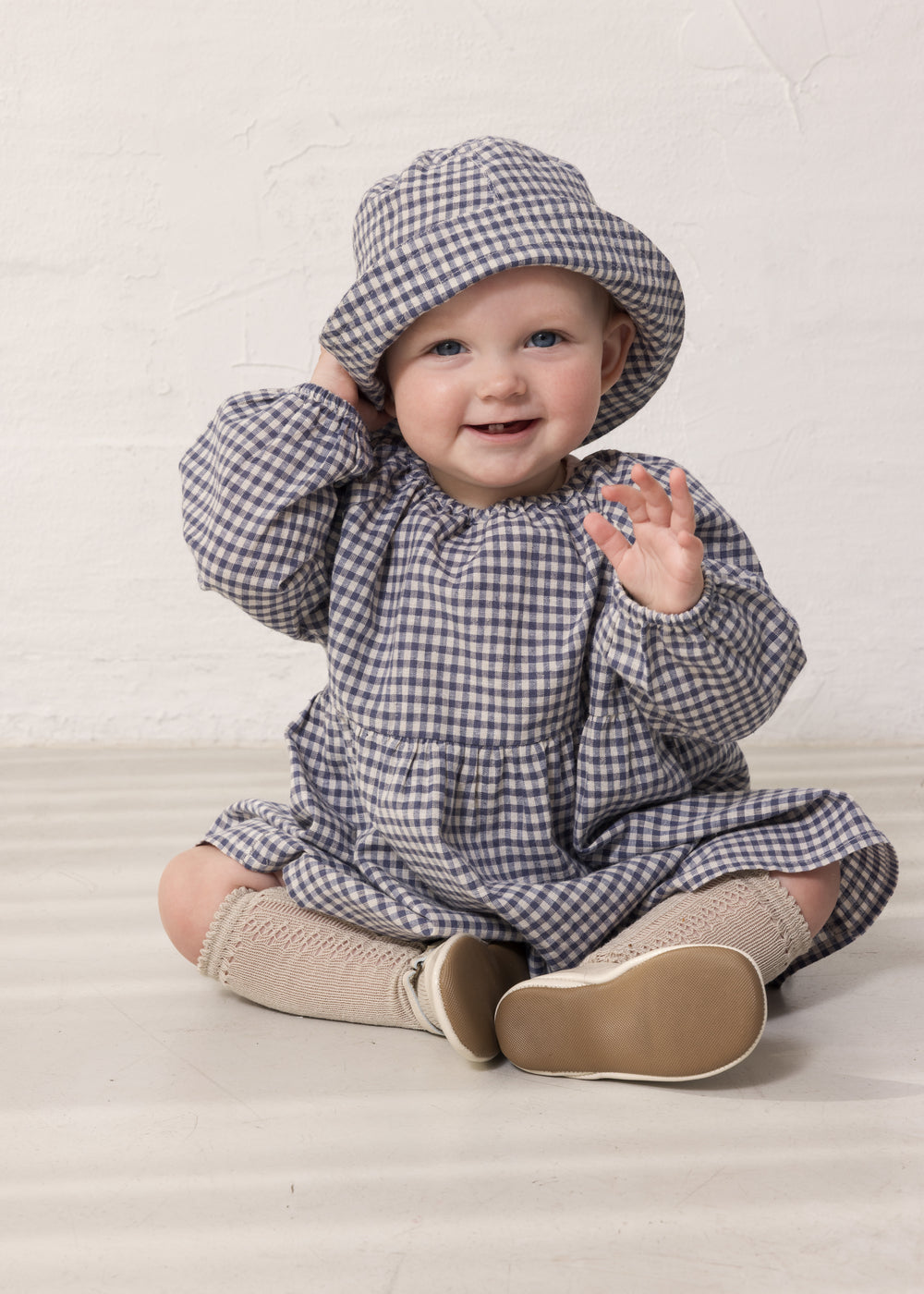 Baby wearing a long-sleeved tunic and hat.