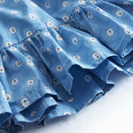 Blue children's pants with small flowers and fringed edges.
