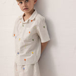 Children wearing a t-shirt and shorts with fruit embroidery.