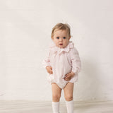 Baby wearing a bright red dress with long sleeves and a peter pan collar.