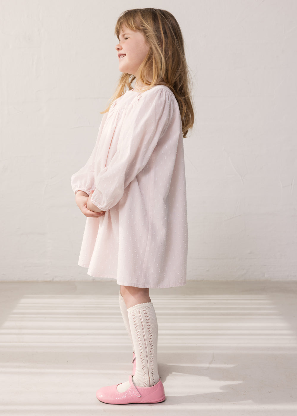 Child wearing a bright red dress with a loose fit.