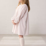 Child wearing a bright red dress with a loose fit.