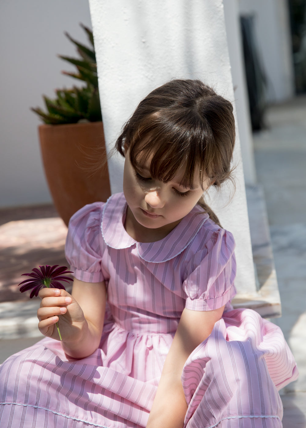 Girl in a light red dress with stripes