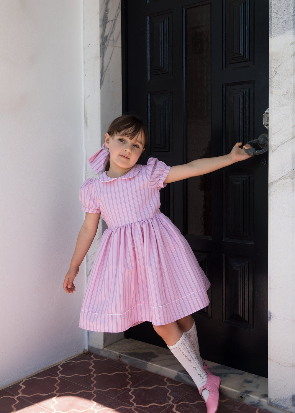 Girl in a light red dress with stripes