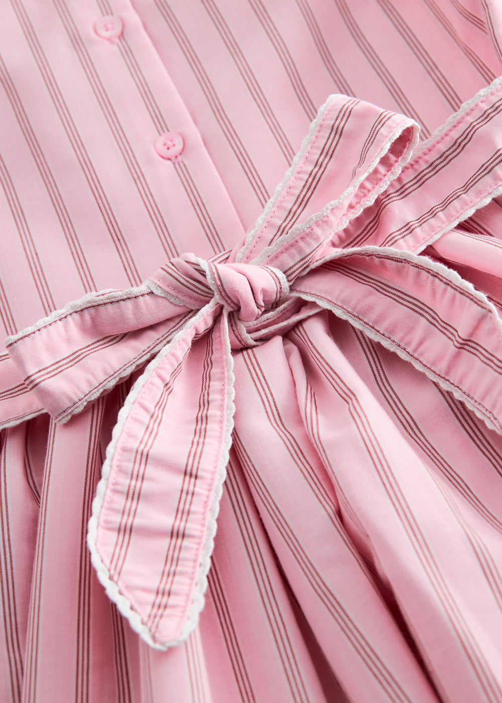 Short bright red dress with stripes for children, with a collar and picot edges, ribbon at the waist, and back zipper closure.