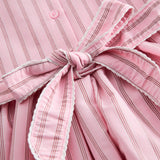 Short bright red dress with stripes for children, with a collar and picot edges, ribbon at the waist, and back zipper closure.