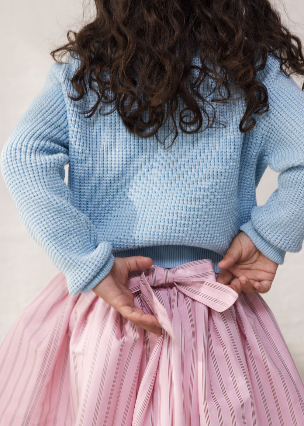 Wearing a blue striped sweater and a bright red skirt.