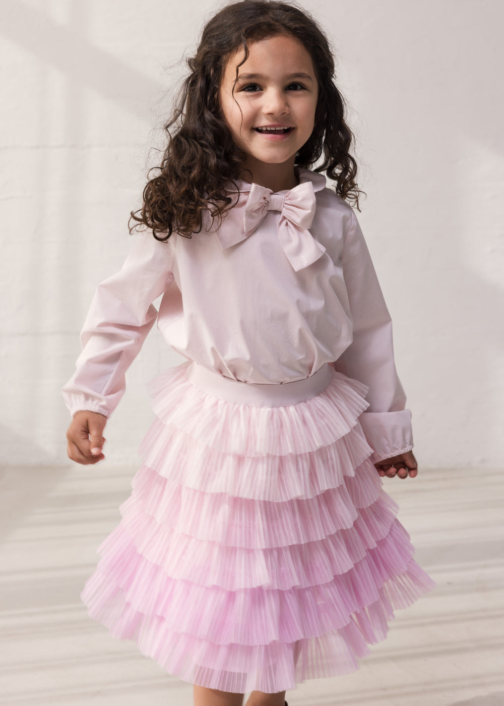 Wearing a red skirt in light, pleated tulle with multiple layers and a blouse.