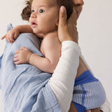 Baby held by a woman with fabric around her body.
