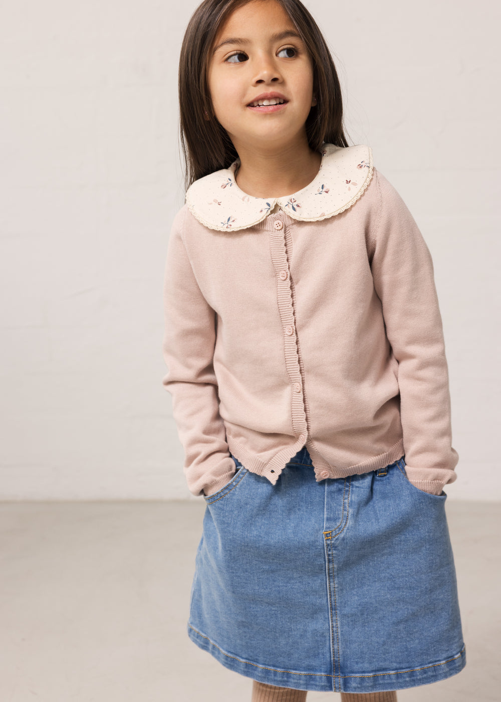 Children's bright red cardigan with collar and denim pants.
