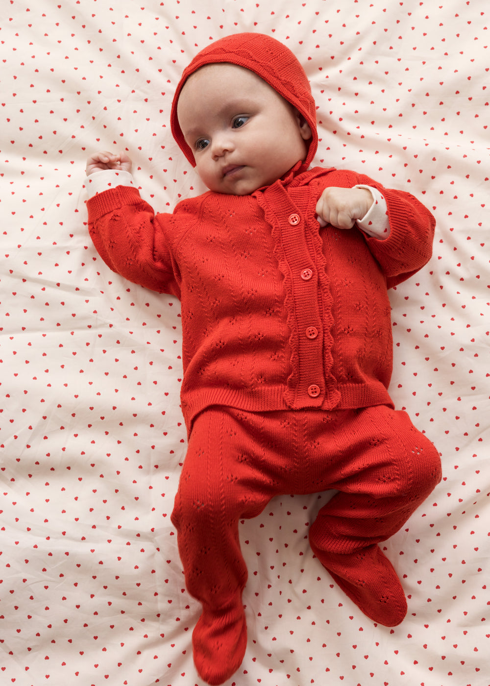 Baby wearing red clothing and a matching hat.
