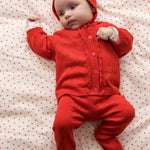 Baby wearing red clothing and a matching hat.