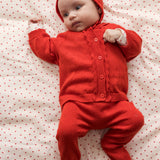 Baby wearing red clothing and a matching hat.