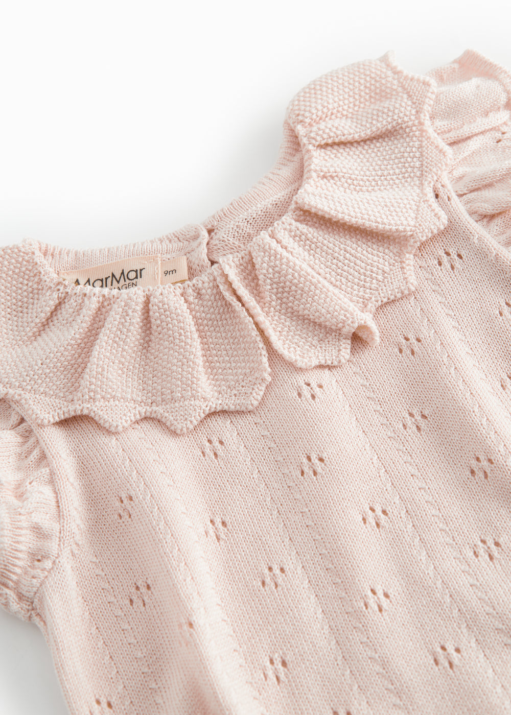 Short sleeve bright red knitted baby bodystocking with a lace pattern and ruffled collar.