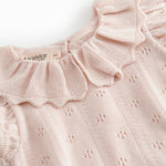 Short sleeve bright red knitted baby bodystocking with a lace pattern and ruffled collar.