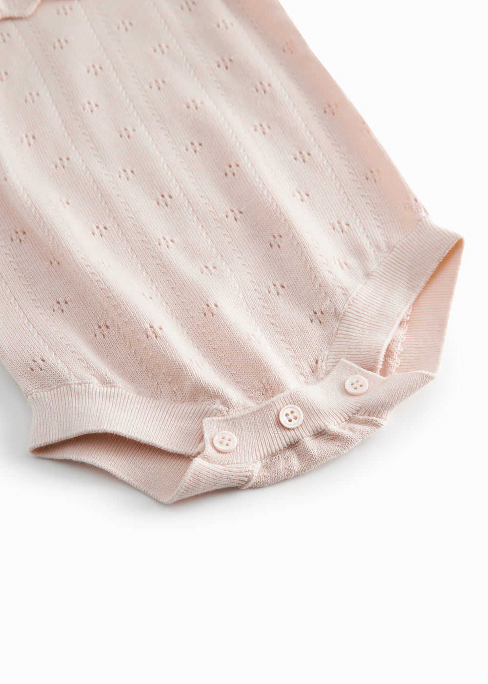 Short sleeve bright red knitted baby bodystocking with a lace pattern and ruffled collar.