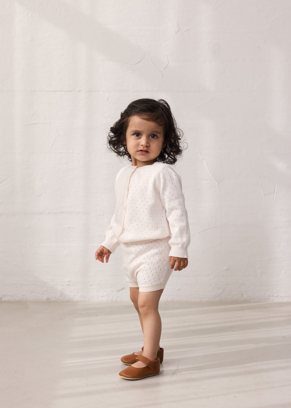 Patched striped cardigan with a delicate hole pattern and button closure, matching shorts.