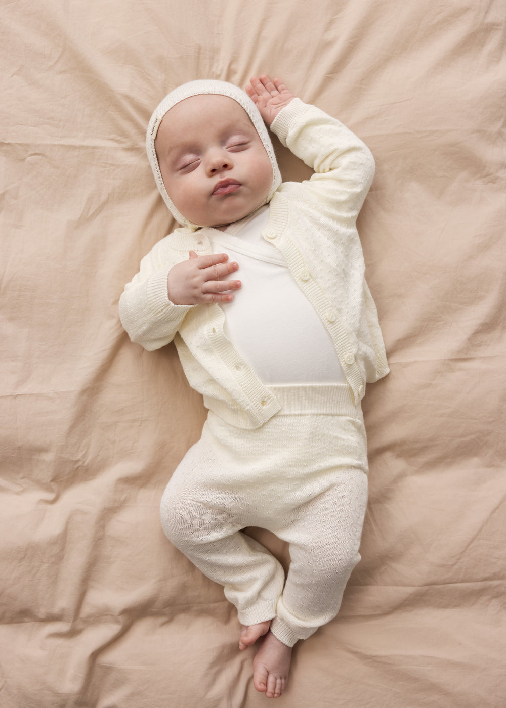 Baby wearing a raw white helmet and matching matching helmet.