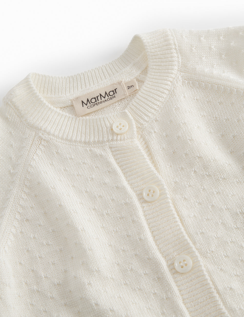 White striped cardigan for baby, with a pretty hole pattern and button closure.