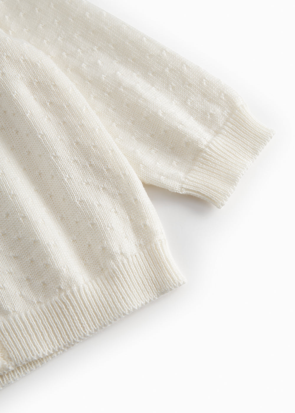 White striped cardigan for baby, with a pretty hole pattern and button closure.