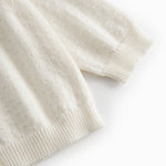 White striped cardigan for baby, with a pretty hole pattern and button closure.