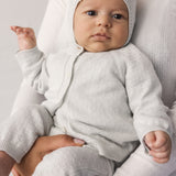 Baby wearing a light green striped cardigan, matching pants and hat.