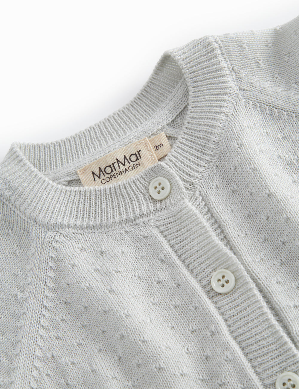 Green striped cardigan for baby, with a pretty lace pattern and button closure.