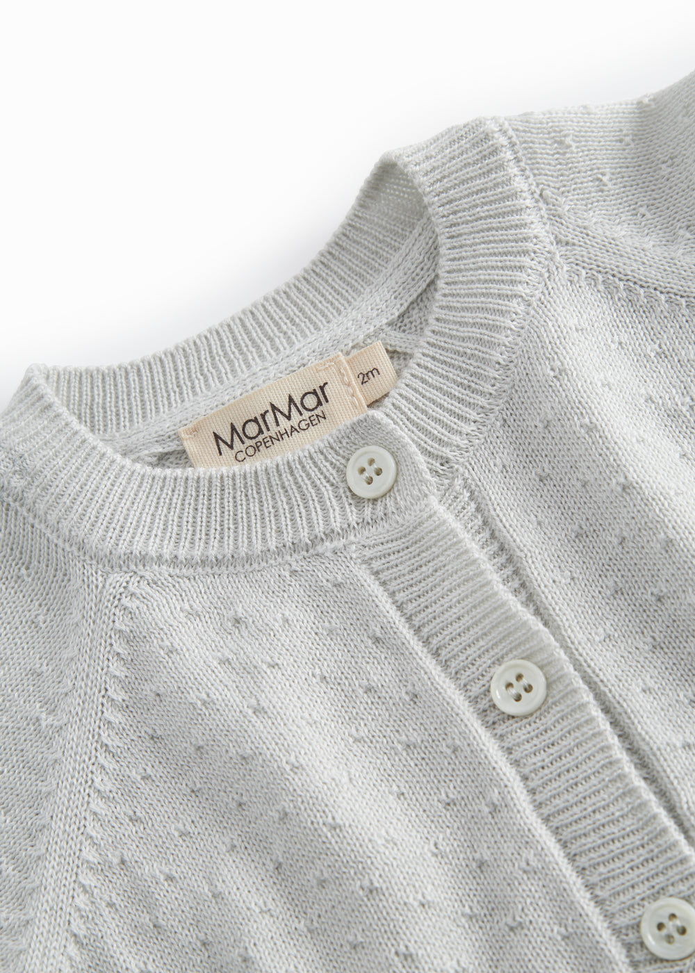 Green striped cardigan for baby, with a pretty lace pattern and button closure.