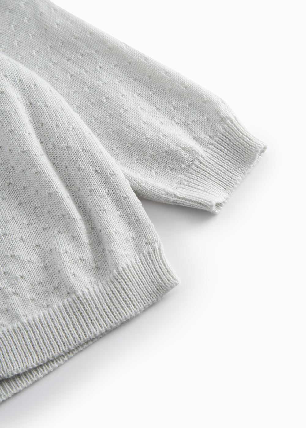 Green striped cardigan for baby, with a pretty lace pattern and button closure.