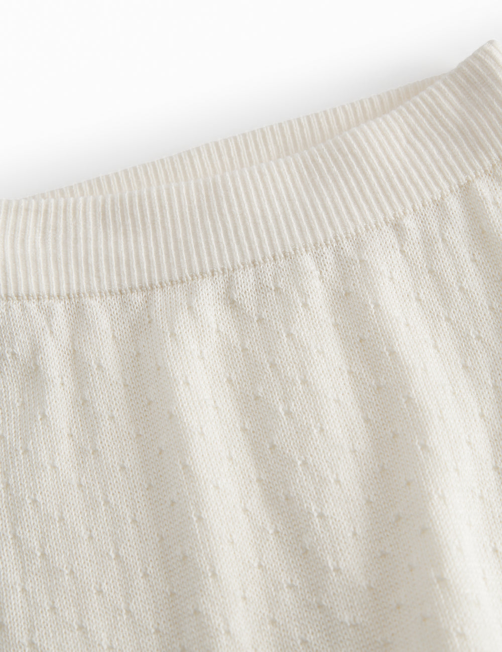 White baby knee pants with a pretty hole pattern.