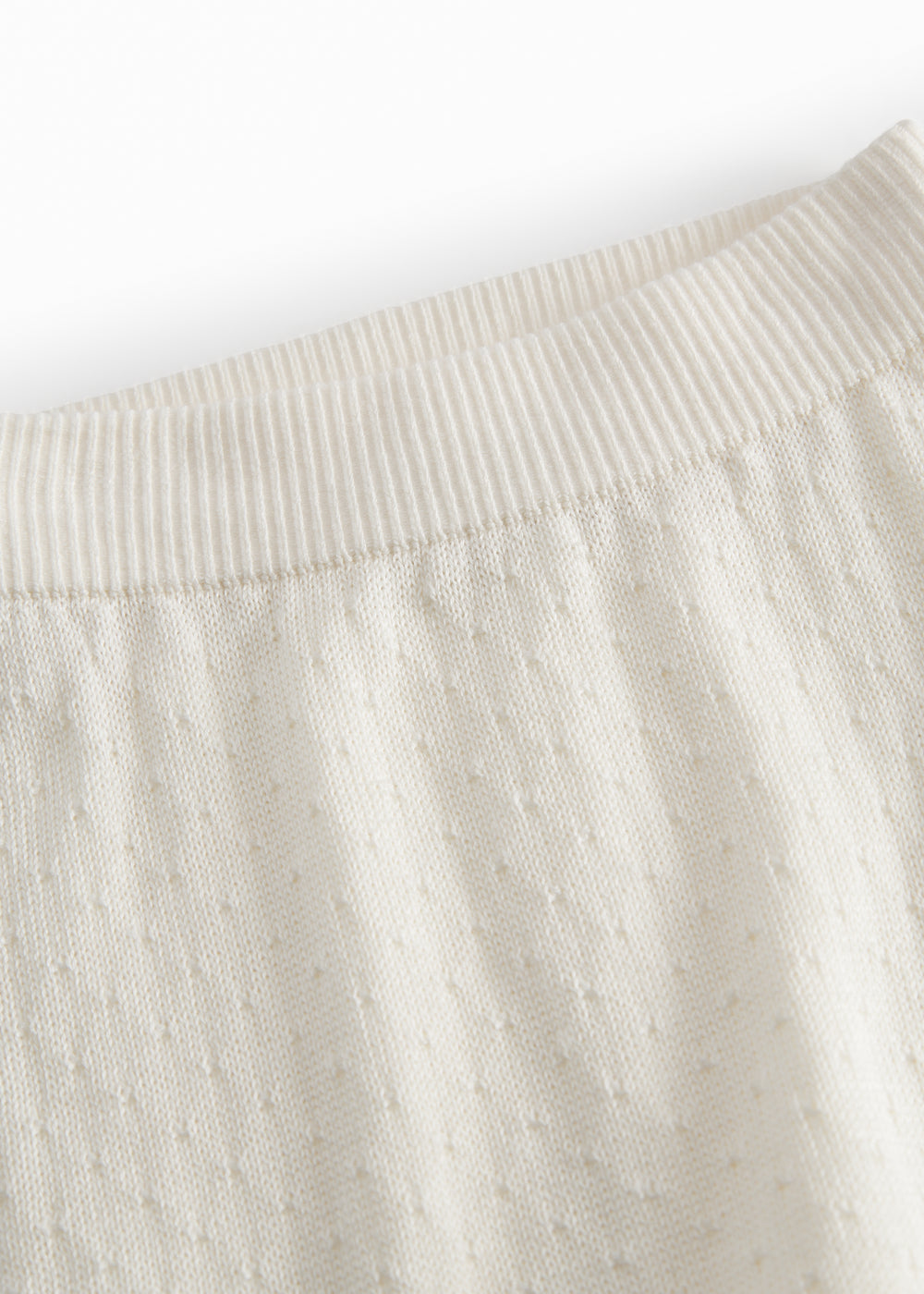 White baby knee pants with a pretty hole pattern.