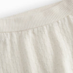 White baby knee pants with a pretty hole pattern.