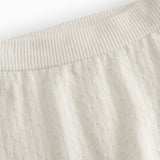 White baby knee pants with a pretty hole pattern.