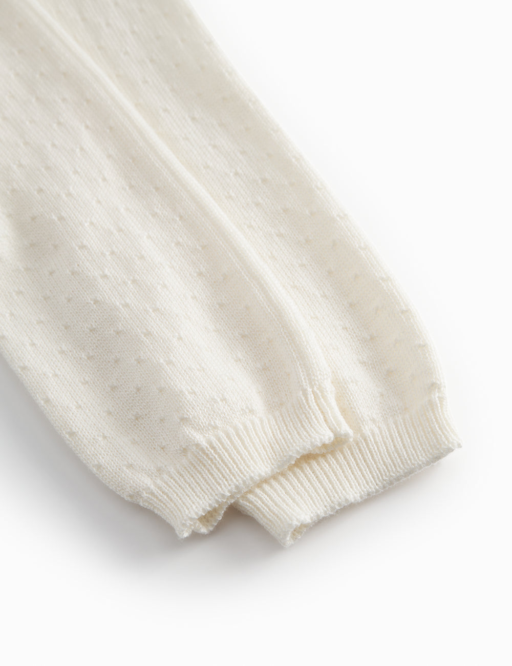 White baby knee pants with a pretty hole pattern.