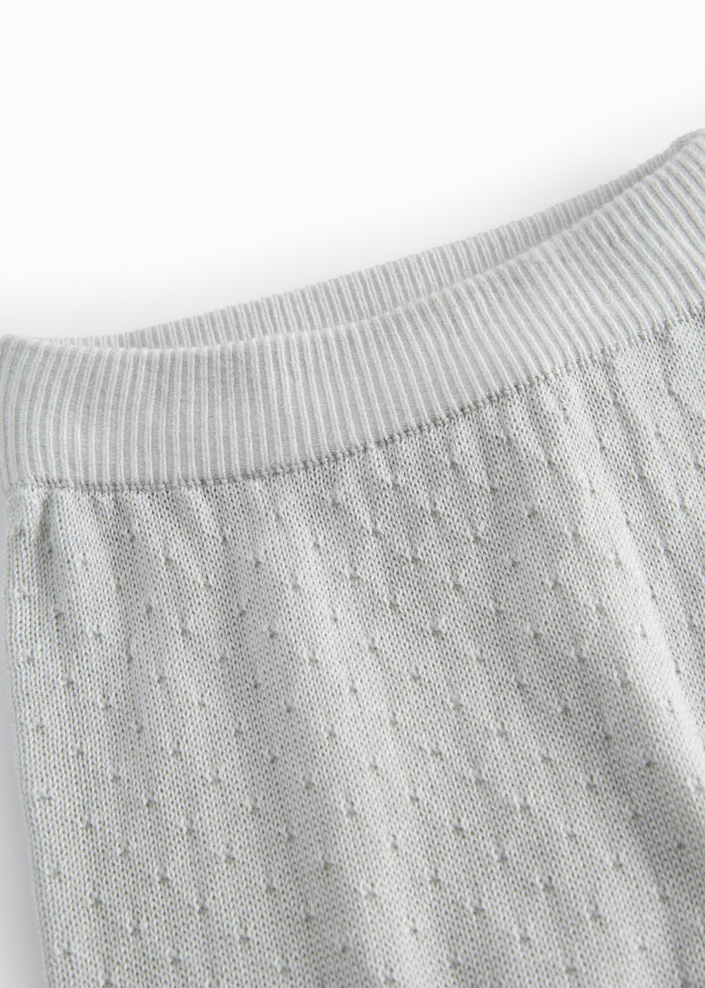 Green baby socks with a fine hole pattern.