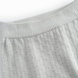 Green baby socks with a fine hole pattern.