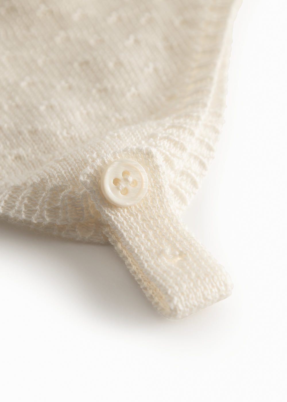 Striped baby hat in white with button closure