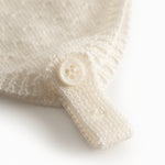 Striped baby hat in white with button closure