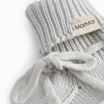 Green striped baby food with a ribbed edge and tie.