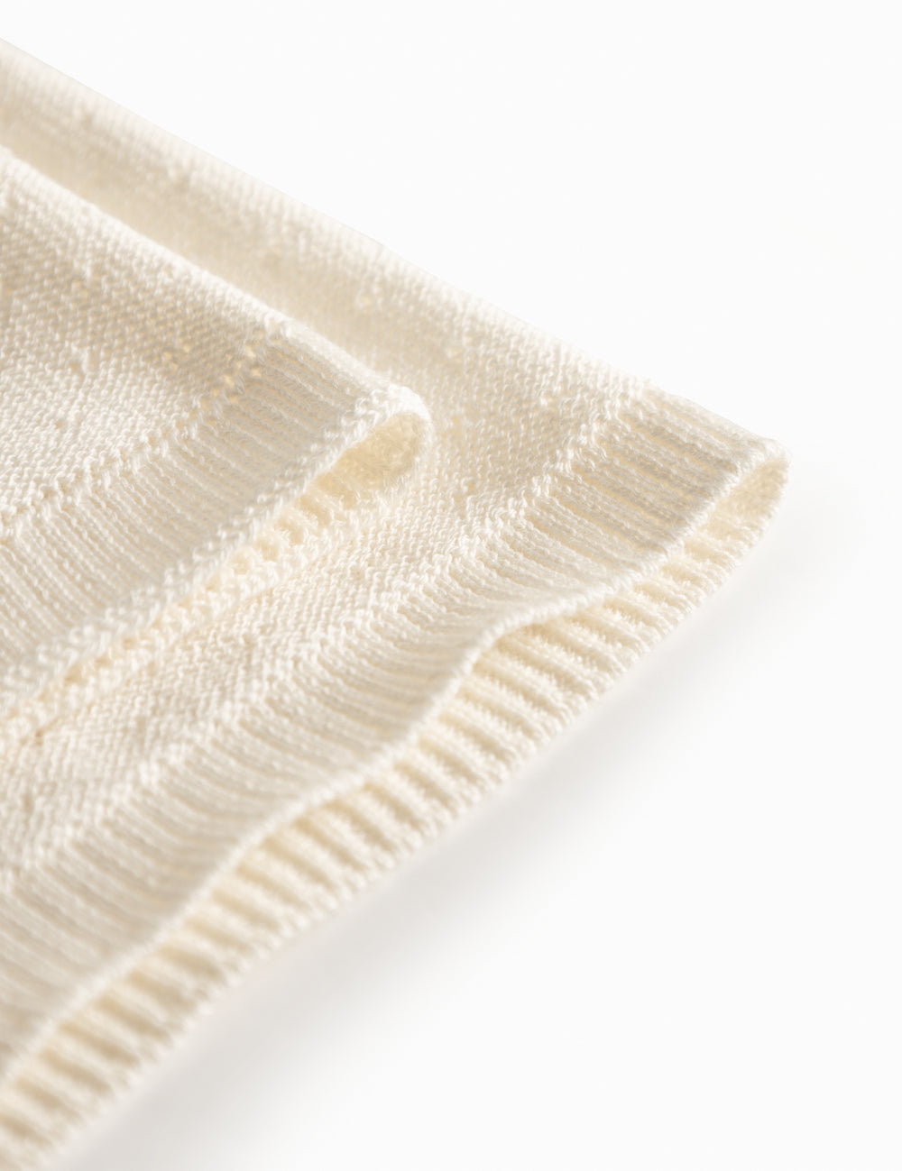 White baby blanket with a hole pattern