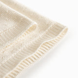 White baby blanket with a hole pattern
