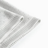 Green baby blanket with a hole pattern