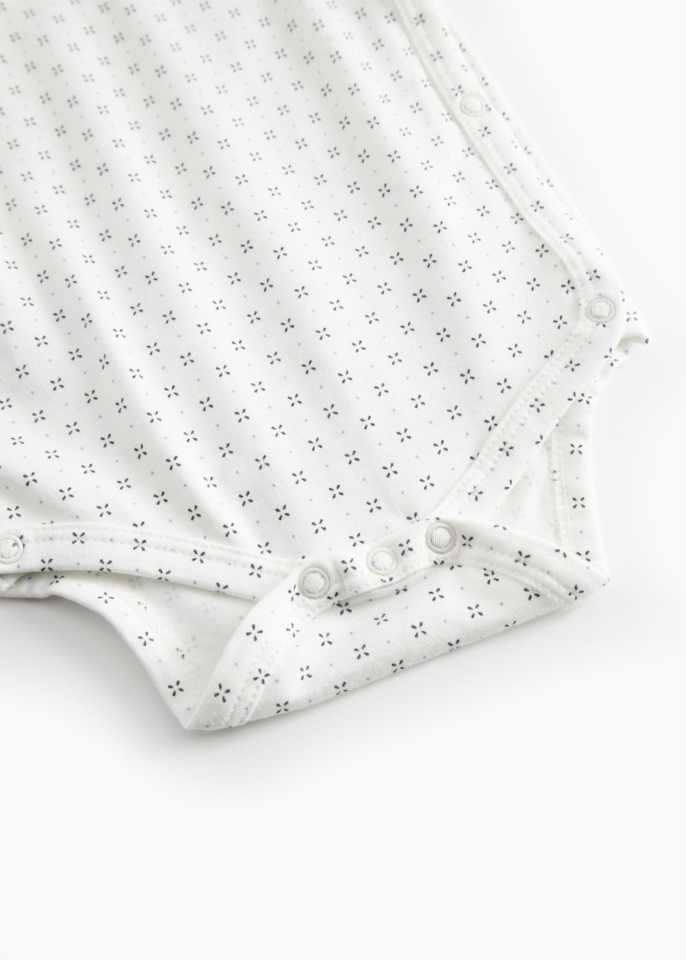 White baby bodysuit with fine pattern