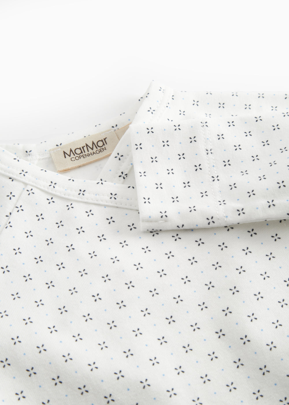 White baby blouse with wrap closure and fine pattern