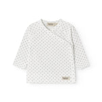 White baby blouse with wrap closure and fine pattern