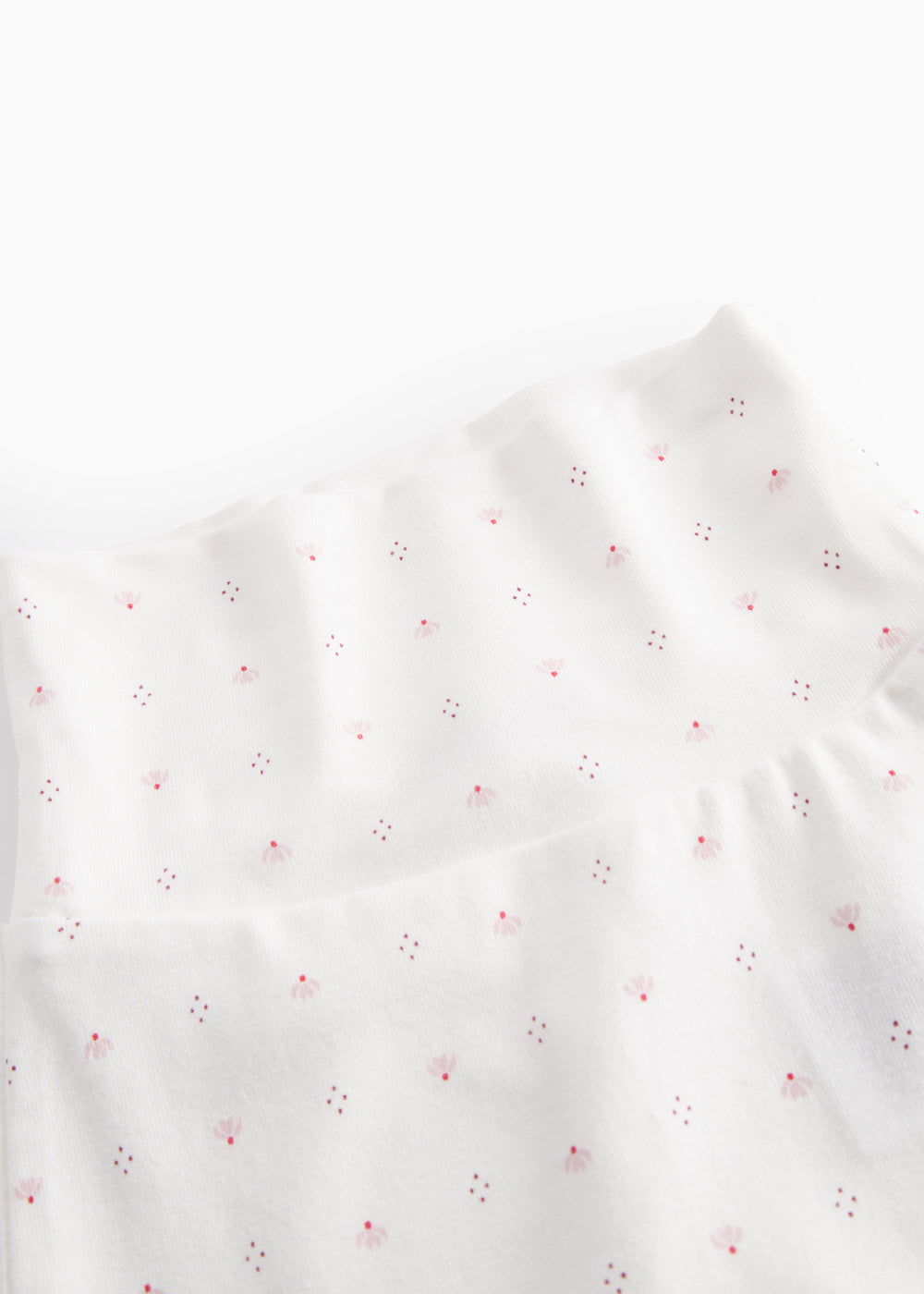White baby trousers with feet and a fine floral pattern
