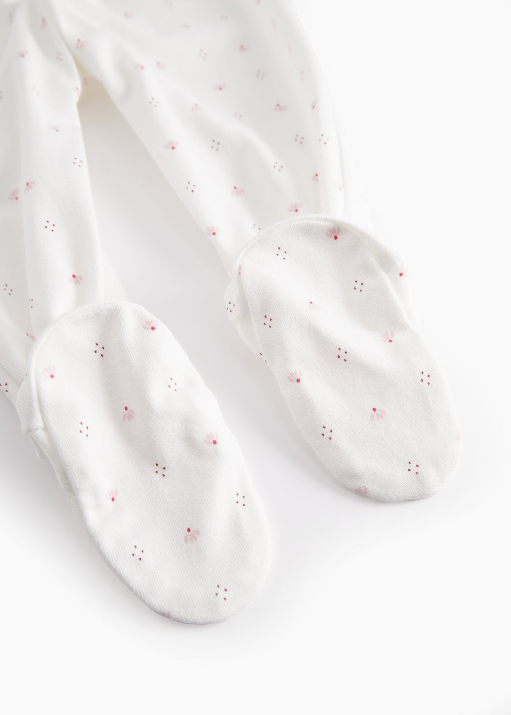 White baby trousers with feet and a fine floral pattern