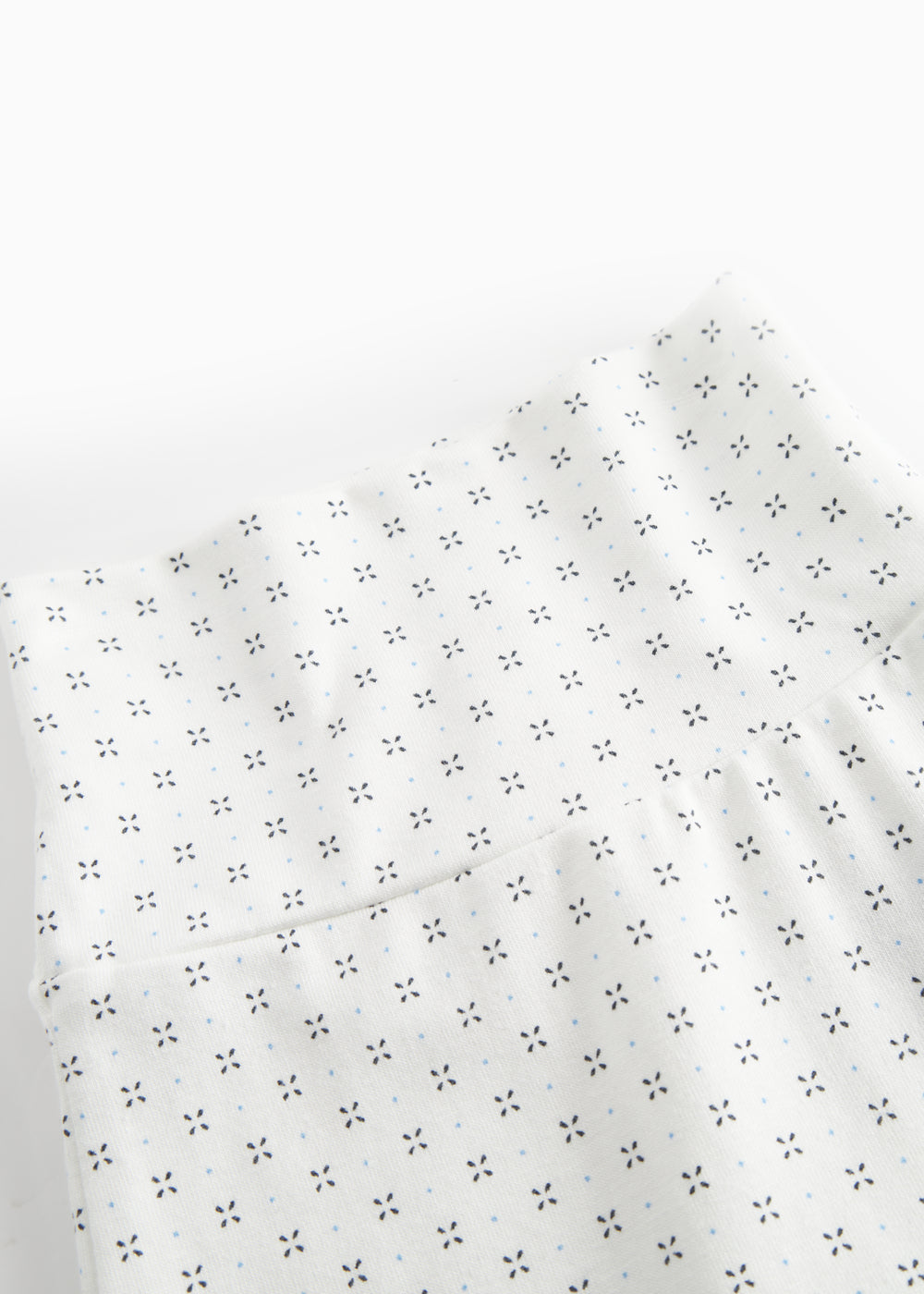 White baby trousers with feet and a fine pattern