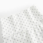 White baby trousers with feet and a fine pattern